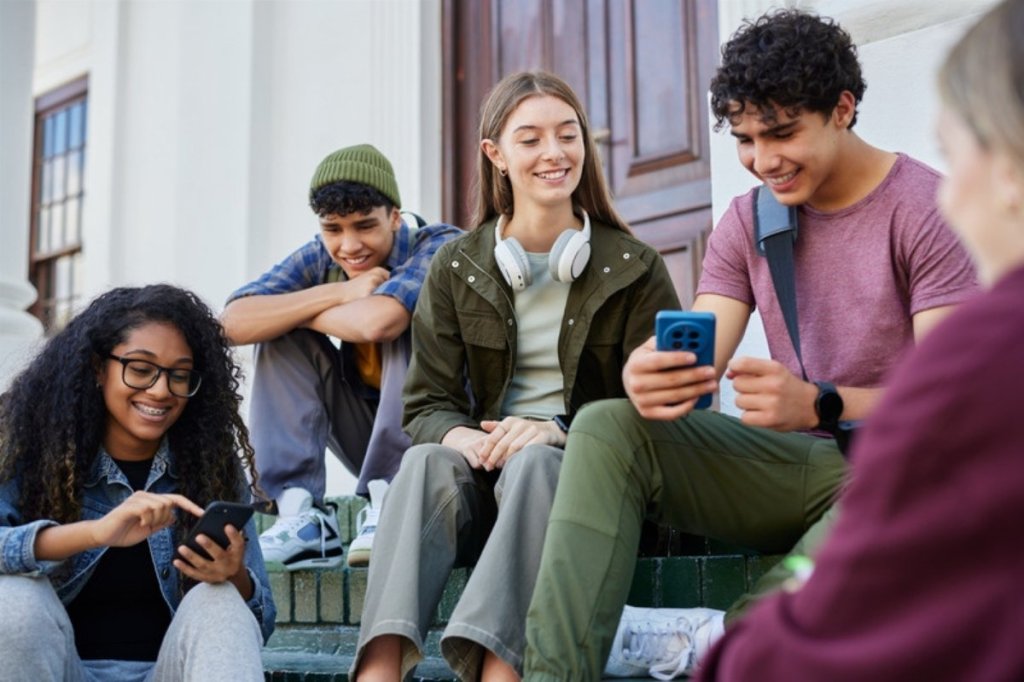 Lycéens assis sur des marches avec leur téléphone