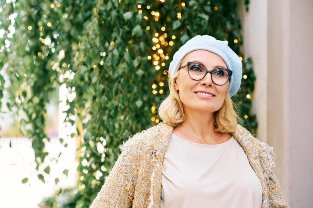 Femme souriante devant un feuillage