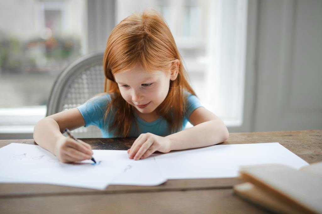 Jeune fille qui fait ses devoirs à la table